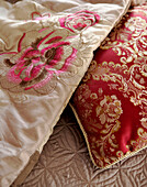 Fabric detail with silk embroidered cushions and quilted bedspread