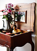 Vase mit Schnittblumen auf antikem Schmucktisch