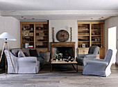 Grey three piece suite and recessed bookshelves in country home