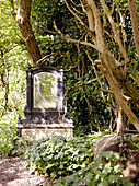 Mirror on stone plinth in garden