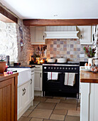 Country kitchen with white fitted units and timber beams