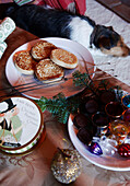 Crumpets und Toasting-Gabel mit Glaswaren und schlafendem Hund