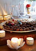 Selection of nuts and mince pies with lit candles