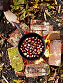 Kastanien (Castanea) beim Kochen auf offenem Feuer Essex England UK