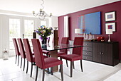 Glass topped table with co-ordinating chairs and wall in renovated Cotswolds mill house England UK