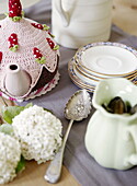 Vintage teaspoon and pink tea cosy on table of Gateshead home Tyne and Wear England UK