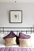 Heart shaped artwork above bed pillow detail and metal headboard Gateshead Tyne and Wear England UK