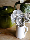 Silberne Löffel und grünes Geschirr in einer Küche in Hexham, Northumberland, England, UK