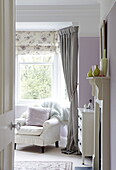 Armchair at window of bedroom in Harrogate home Yorkshire England UK