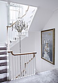 Candelabra and artwork in white staircase of London home UK