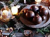 Antique bowling balls and lit candles on tabletop in festive Oxfordshire home, England, UK