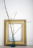 Sprigs of blossom in vase with empty picture frame in Warwickshire home, England, UK