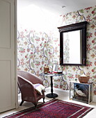 Wicker chair with antique wooden mirror in skylit corner of Oxfordshire home, England, UK