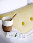 Tasse und Löffel mit Fernbedienung auf dem Arm des Sofas in einem Haus in Bussum, Niederlande