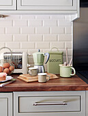 Cafetiere und Tassen mit Toaster und Eierkorb auf hölzernem Küchentisch in einem Haus in Nord-London, England, UK