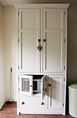 White kitchen dresser with concealed microwave unit in North London home, England, UK
