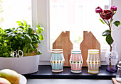Paper lanterns and herbs with house shaped chopping boards on windowsill of Mattenbiesstraat family home, Amsterdam, Netherlands