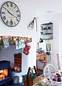 Large clock above fireplace with desk and chair in Devonshire farmhouse UK