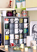 Verschiedene Tassen in einem Metallregal in der Küche eines Londoner Familienhauses England UK