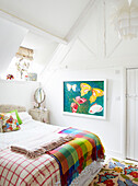 Schmetterlingskunstwerk im Schlafzimmer mit karierten Decken in einem Bauernhaus in Oxfordshire, England, UK