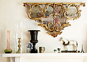 Ornate gilt salvage and ornaments above mantlepiece in London townhouse England UK