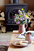 Wildflower arrangement in pottery jugs on coffee table in Derbyshire farmhouse England UK