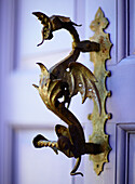 Brass dragon door knocker on purple exterior of detached house in Welsh Border regions UK