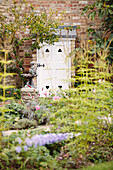 Cremefarbener Anstrich der Hintertür im ummauerten Garten eines Hauses in Bicester, Oxfordshire, England