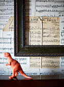 Leerer Bilderrahmen über Partituren mit Dinosaurier in einem Haus in Kent, England, UK