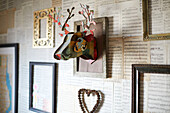 Wall-mounted deers head with empty picture frames with music scores in Kent home England UK