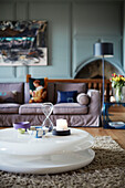 Low white coffee table in light blue panelled living room in Northumbrian manor house England UK