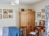 Blaue Decke auf Einzelbett mit Holzschrank und antikem Frisiertisch und Stuhl in Hexham Bauernhaus Northumberland UK