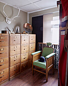 Bowler hat on green armchair with wooden filing cabinet in Sunderland home Tyne and Wear England UK