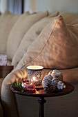 Beleuchtetes Teelicht und Weihnachtsdekoration mit Wunschband im Wohnzimmer in Oxfordshire, England, Vereinigtes Königreich