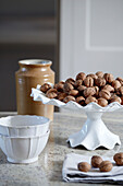 Walnuts on ceramic dish with earthenware pot in modernised Northumbrian country house UK