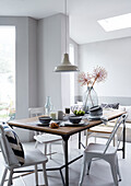 Pendant light above dining table with bowls in studio, UK
