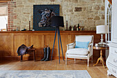 Reitausrüstung mit Kunstwerk, Lampe und Stuhl in einem Haus in Kent, Nordostengland, UK