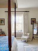 Niedriger Sessel am Fenster des Schlafzimmers mit Himmelbett in Capheaton Hall in Northumberland, UK