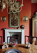 Wooden table and chairs with ornaments in red dining 19th century Georgian dining room in Talgarth, Mid Wales, UK