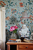 Detail of wooden bedside table with peonies and chinese table lamp in 19th century Georgian townhouse in Talgarth, Mid Wales, UK