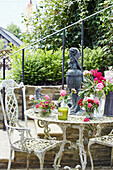 White ironwork chair and table on garden terrace of Georgian home in Talgarth, Mid Wales, UK