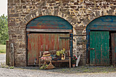Wooden bench in arched stone barn exterior Powys, Wales