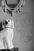 China dog ad wire sculpture of face with mirror frame in Powys cottage, Wales, UK