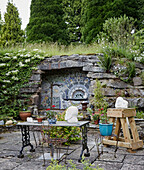 Table and chair on Herefordshire terrace with mosaic tiling, UK