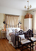 Pair of vintage chairs at foot of double bed in Chippenham home, Wiltshire, UK