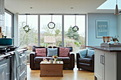 Braunes Ledersofa und Stühle im Fenster eines Hauses in Worcestershire, England, UK