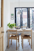 View through open doorway to table and chairs in kitchen of Edwardian London flat, UK