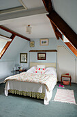 Hellblauer Dachbodenausbau mit gestepptem Bettbezug in einem Haus in Syresham, Northamptonshire, UK