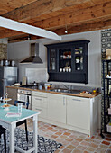 Contrasting patterns and terracotta floor tiles in Brittany kitchen France