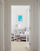 View through open doorway to lamp on side table with armchair in York home, UK